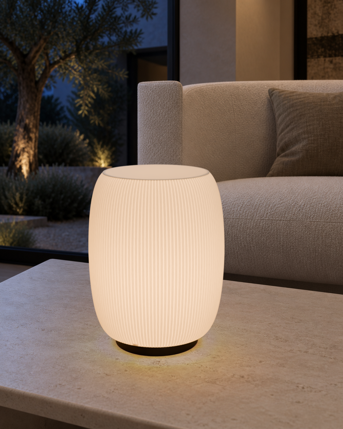 Lámpara Cápsula encendida sobre una mesa de piedra, junto a un sillón y un jardín.
